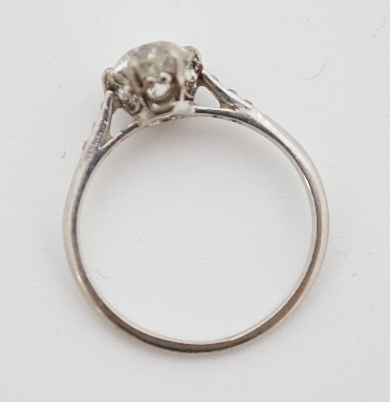 A platinum and single stone diamond ring, with diamond chip set shoulders